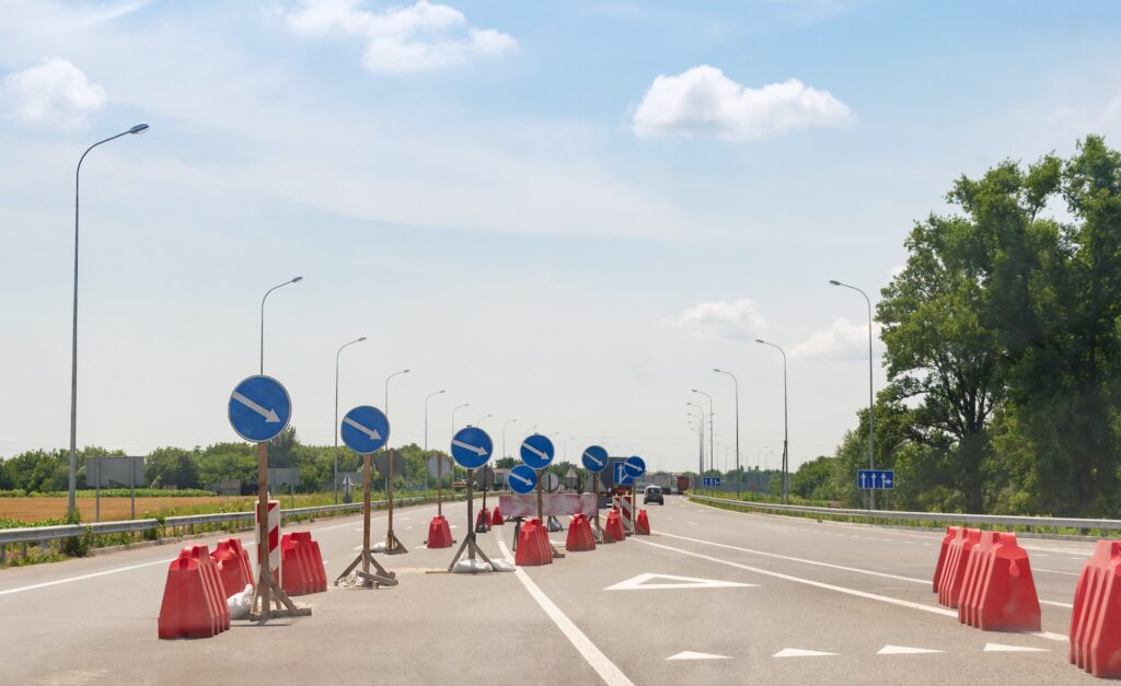 A lot of road signs showing directions on an asphalt highway.