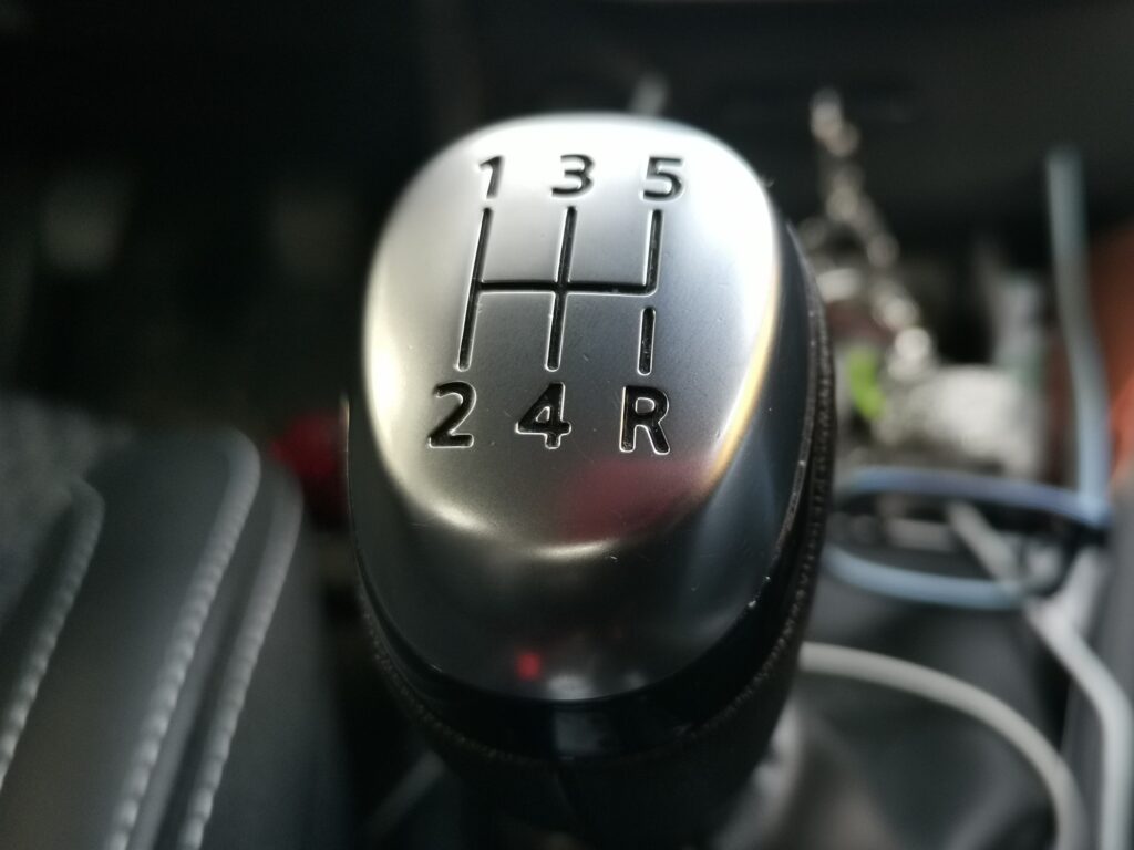 The Art of Manual Downshifting :  Black interior of a modern car, 5-speed manual shift car gear lever.