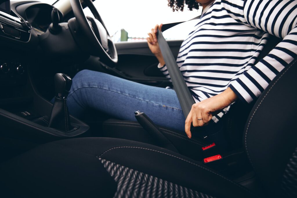 Art of Moving Off | Step-by-Step Guide to Confident Starts | Close Up Of Female Driver In Car Fastening Seatbelt At Start Of Journey