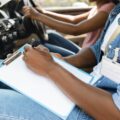 Driving instructor taking notes during exam, Understanding Scoring Method in the K53 Driving Licence Test
