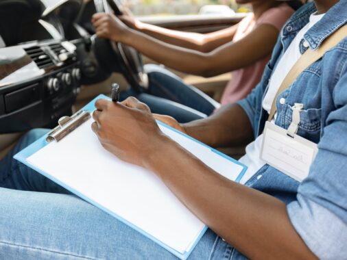 Driving instructor taking notes during exam, Understanding Scoring Method in the K53 Driving Licence Test