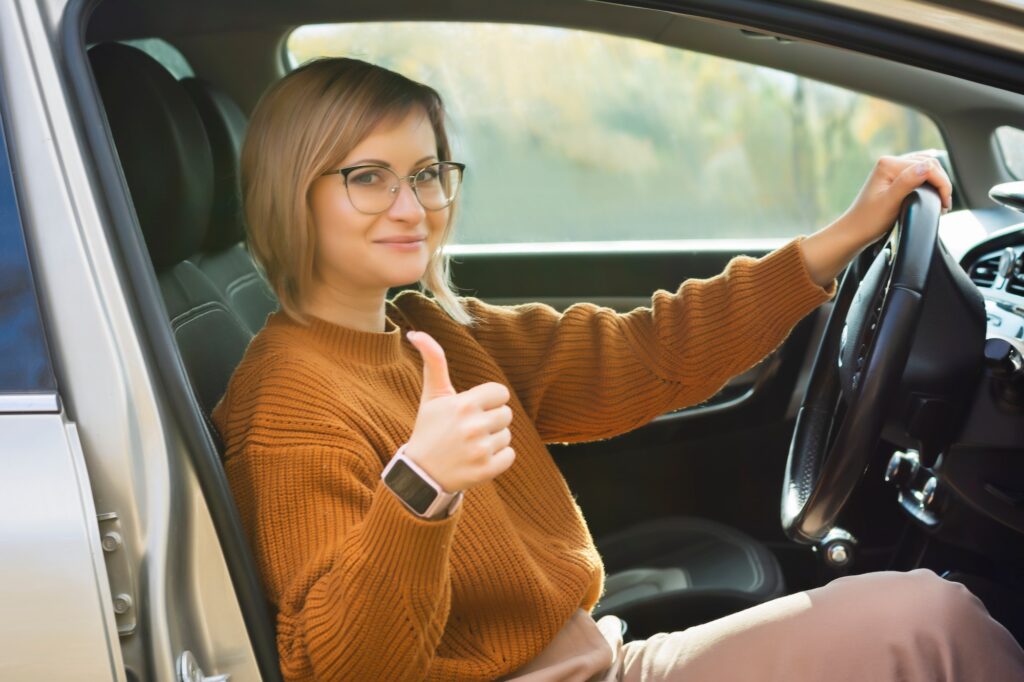 Driving school woman successfully passed exam in driving school looking sitting in car | Understanding the Scoring Method in the K53 Driving Licence Test