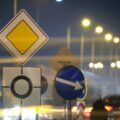 Roundabout road signs with blurred cars on city street traffic at night. Urban transportation | K53 Information Signs | Pass Your Learners Licence in South Africa