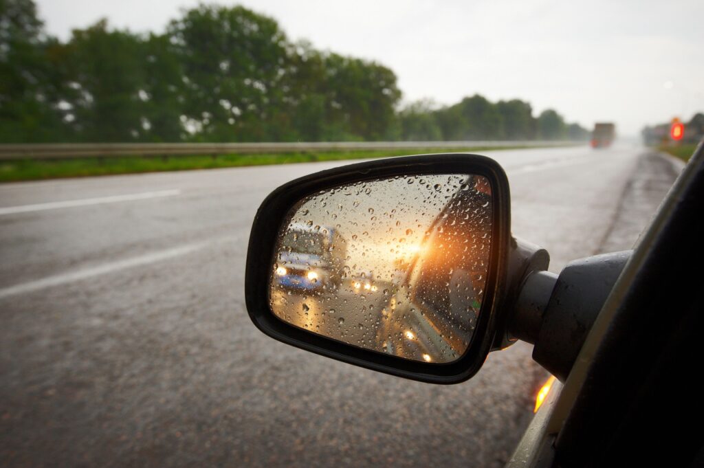 Mastering K53 Defensive Driving: Truck in a rear view mirror at sunset