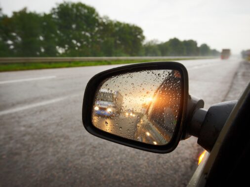 Mastering K53 Defensive Driving: Truck in a rear view mirror at sunset
