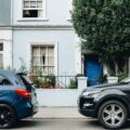 Two parked cars in front of an apartment entrance | Understanding Parallel Parking: What it is and Why is it Important?