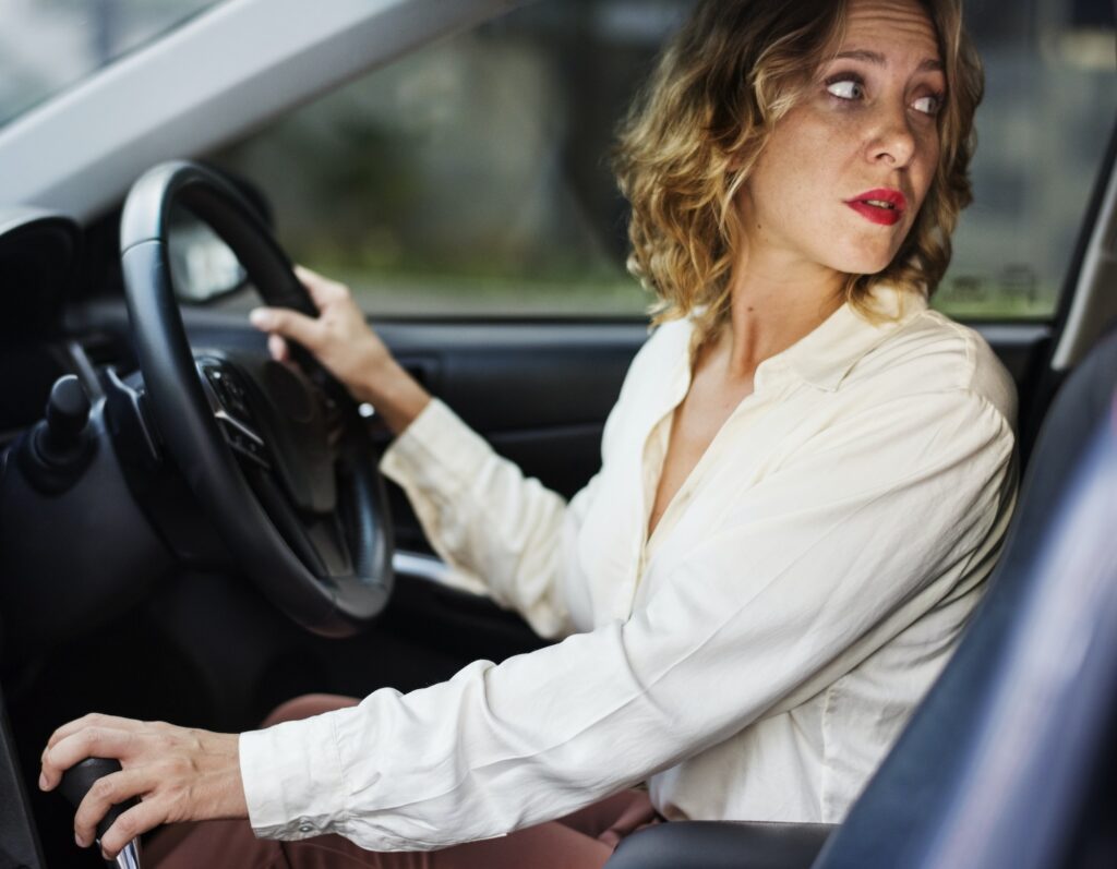 Woman driving a car in reverse: Mastering the Straight-Line Reverse Like a Pro