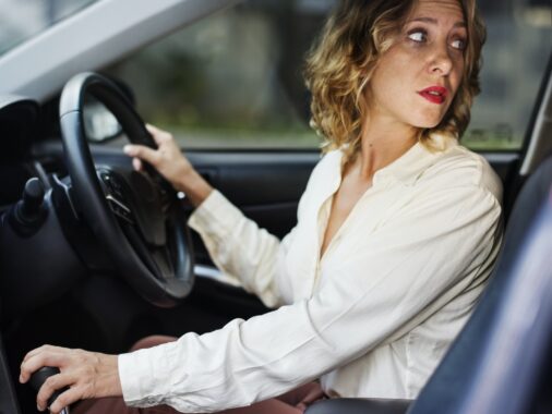 Woman driving a car in reverse: Mastering the Straight-Line Reverse Like a Pro
