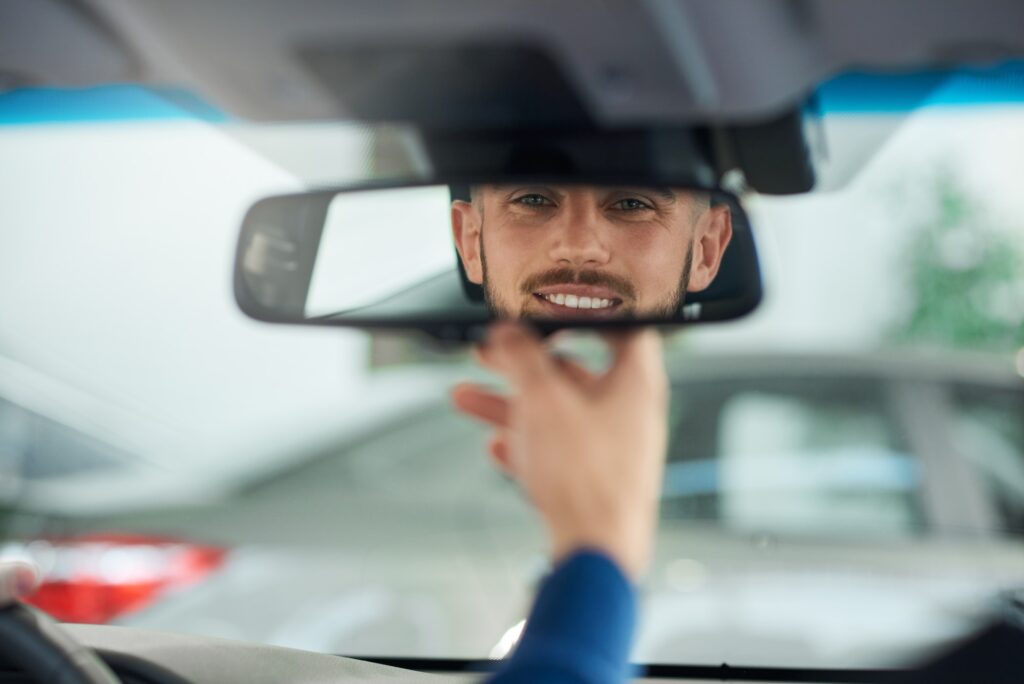 Mastering K53 Defensive Driving: Young man looking in rear view mirror